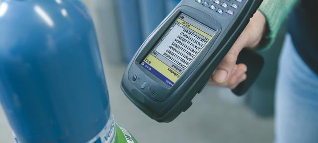 A hand-held scanner reading the bar code on a gas cylinder
