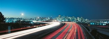 Highway in the evening with long time image exposure. View of San Francisco in the background.